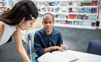 A blind man talking with a female colleague